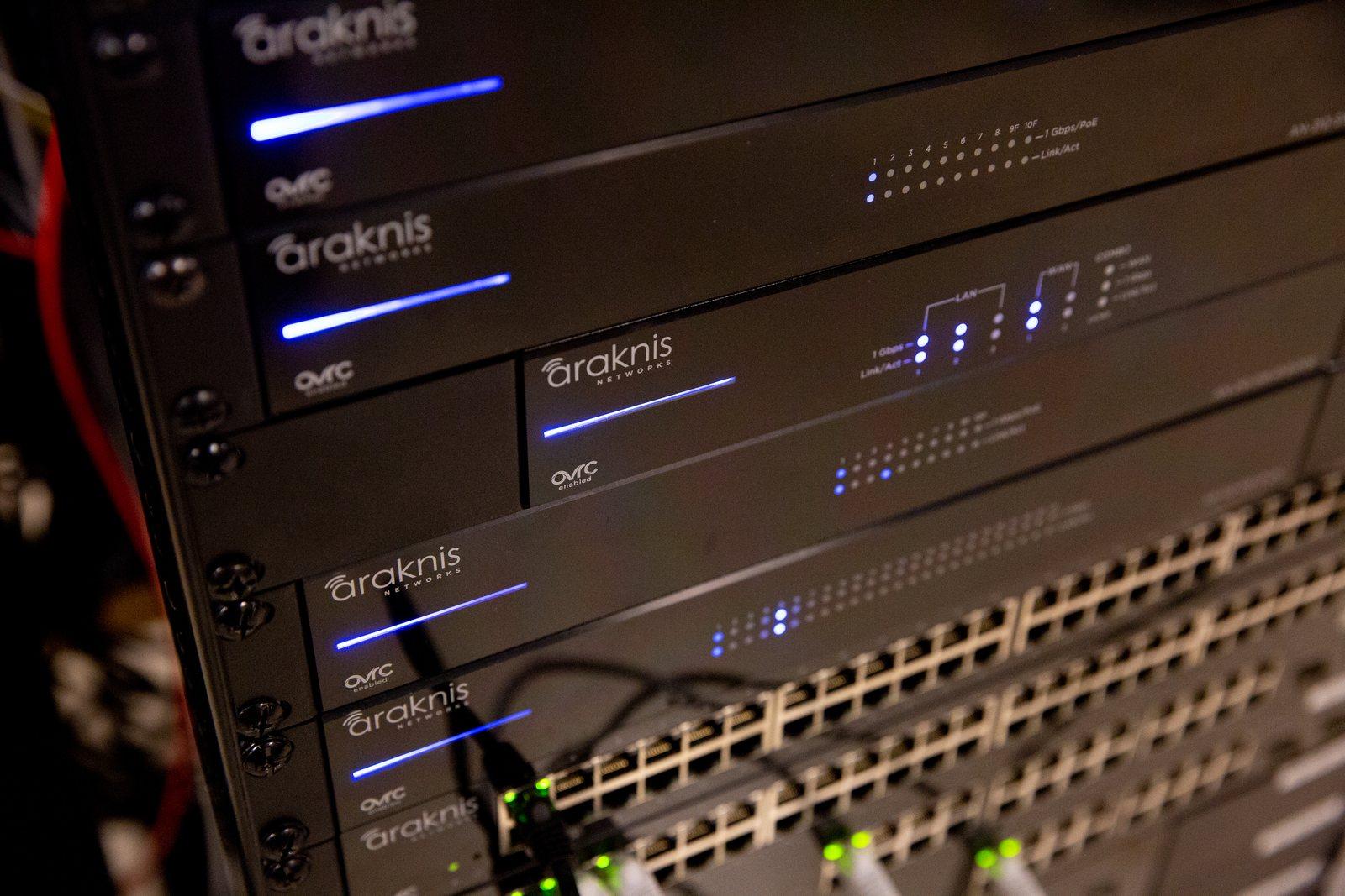 Close-up of a rack of Araknis network switches and routers with patch cables