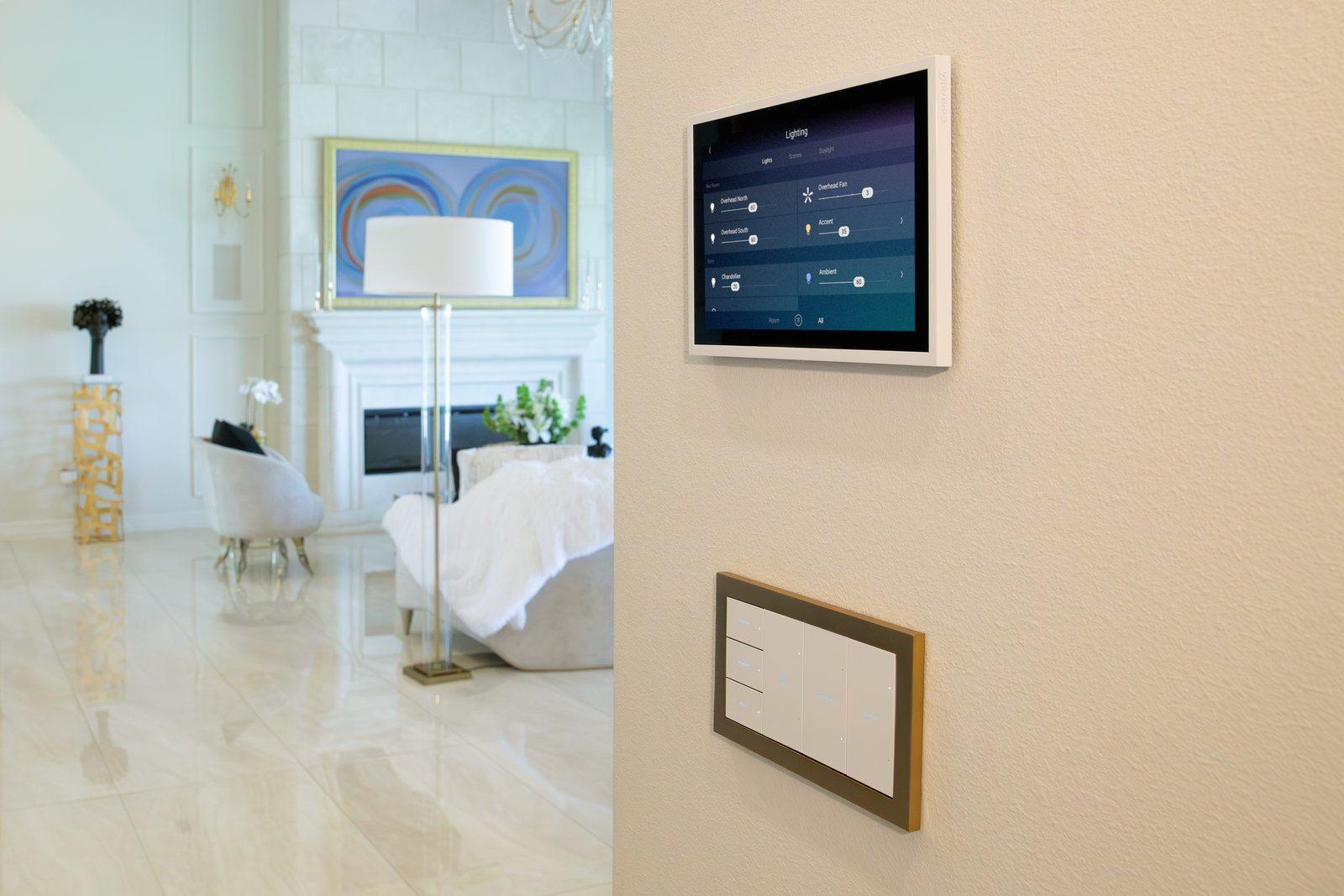 Control4 touch screen and keypad on the wall of a bright living room