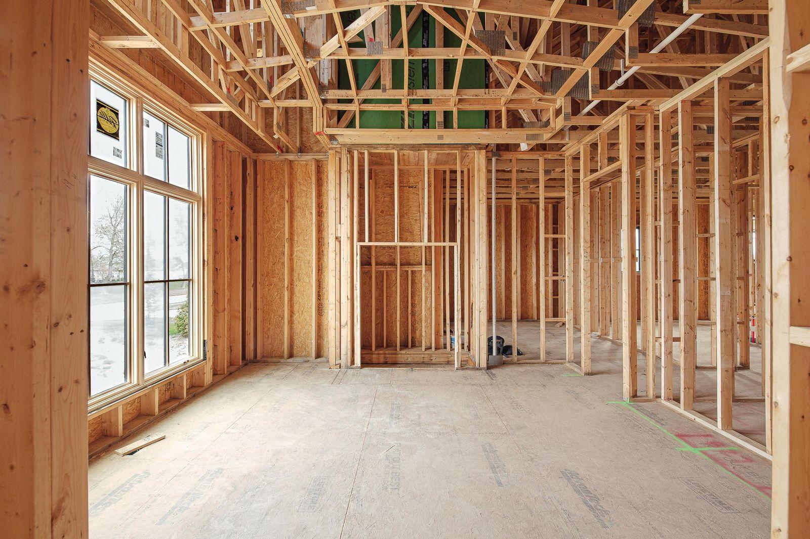 Interior of a new home at the framing stage with open stud walls and trusses