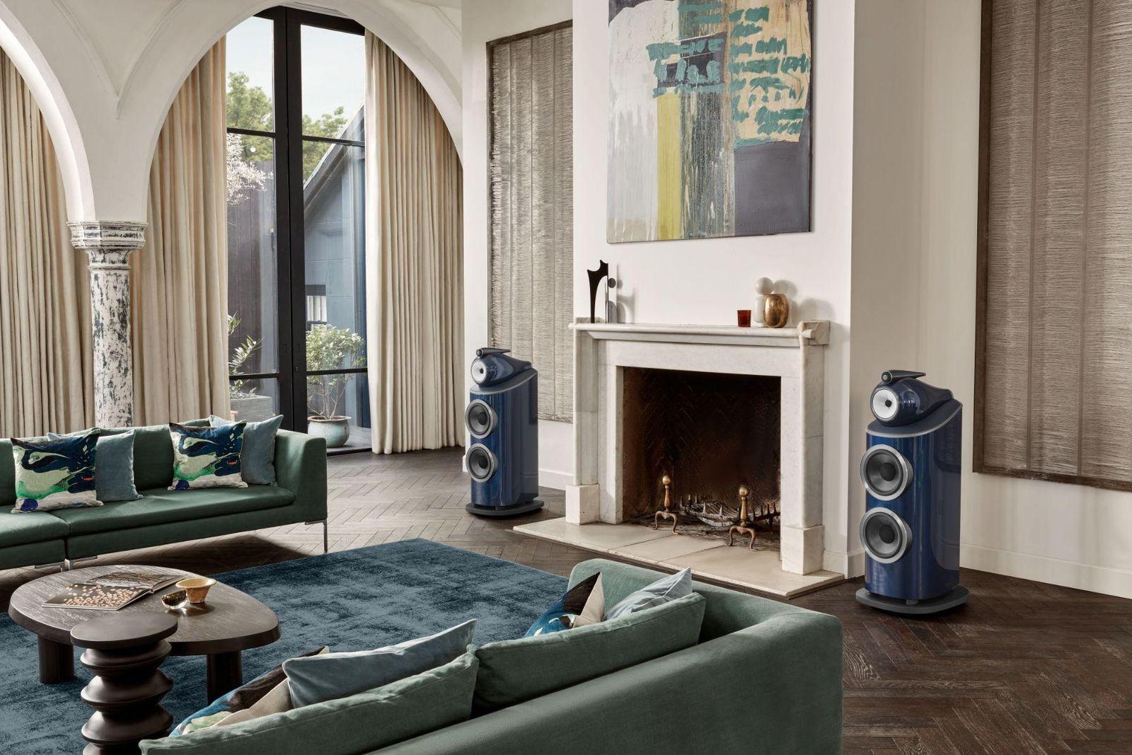 Living room with two floor-standing speakers flanking a fireplace
